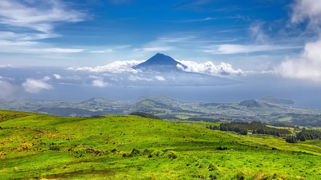 Scenic view of Faial Island featuring Pico Mountain under a cloudy sky.