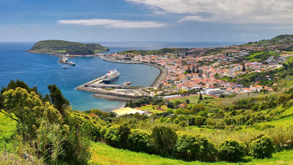 Panoramic view of Horta, a coastal town on Faial Island, with harbor and surrounding landscape.