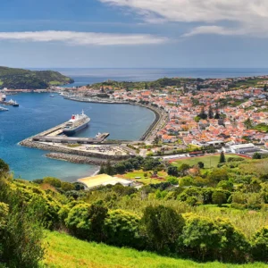Panoramic view of Horta, a coastal town on Faial Island, with harbor and surrounding landscape.