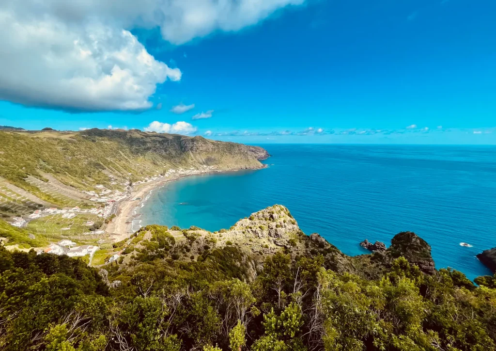 Panoramic view of the coastline and ocean surrounding Santa Maria Island under a blue sky.
