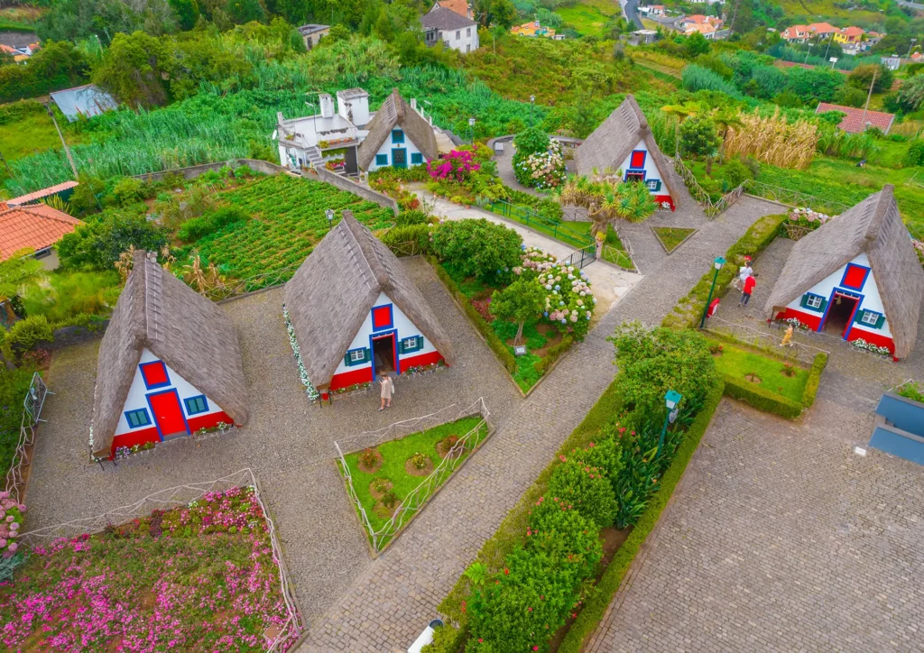 Aerial view of traditional thatched roof houses in Santana, surrounded by gardens and pathways.