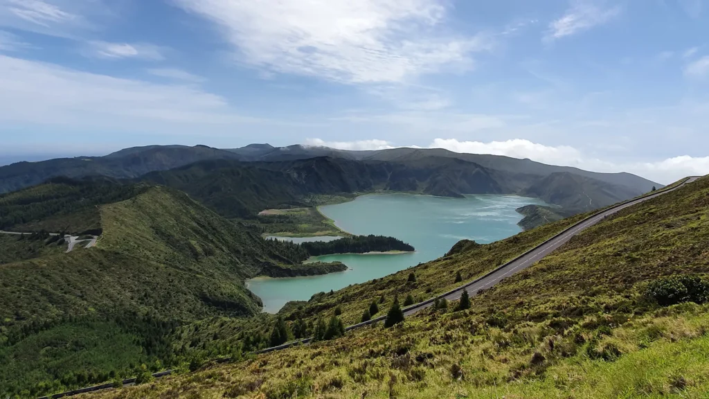 A panoramic view of the Sete Cidades lakes surrounded by green hills and mountains.