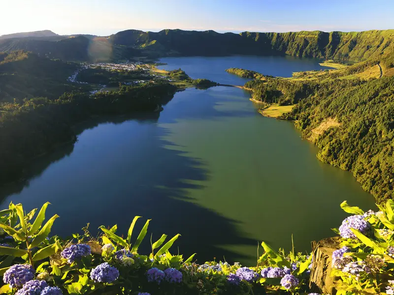 Aerial view of Seven Cities Lake with lush greenery and calm waters under sunlight.