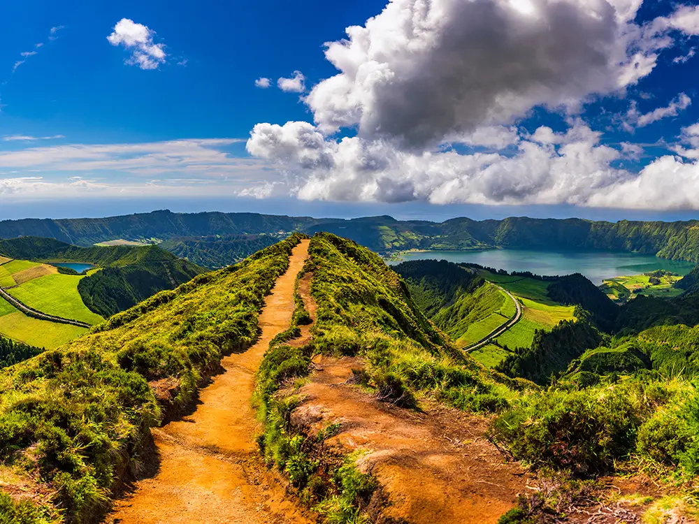 Path leading to a viewpoint overlooking Sete Cidades with lakes and hills in the background.
