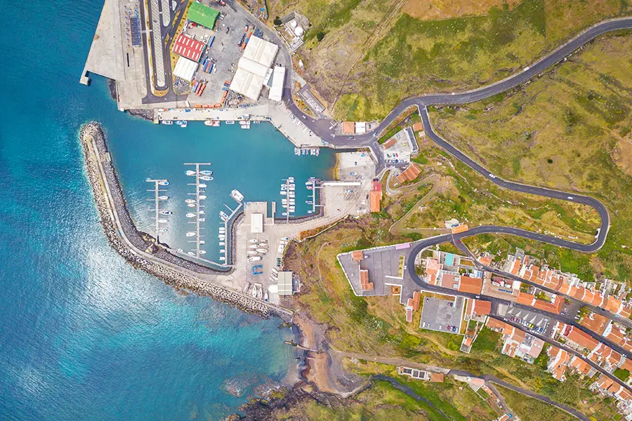 Aerial view of a harbor on Santa Maria Island with boats docked and surrounding roads.